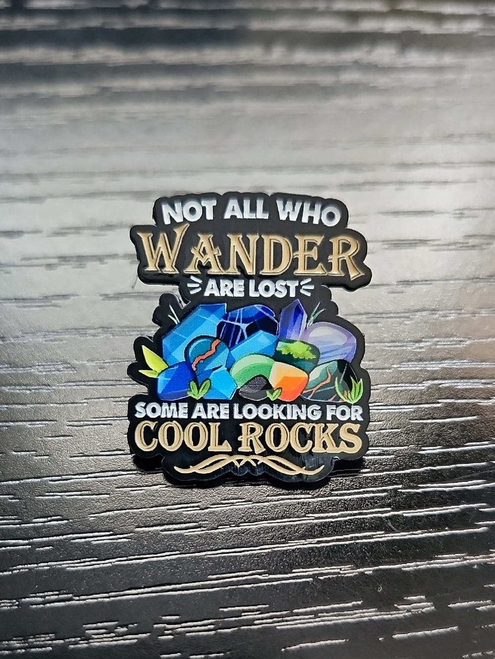 Enamel Pin "Not All Who Wander" with Colorful Rocks Design